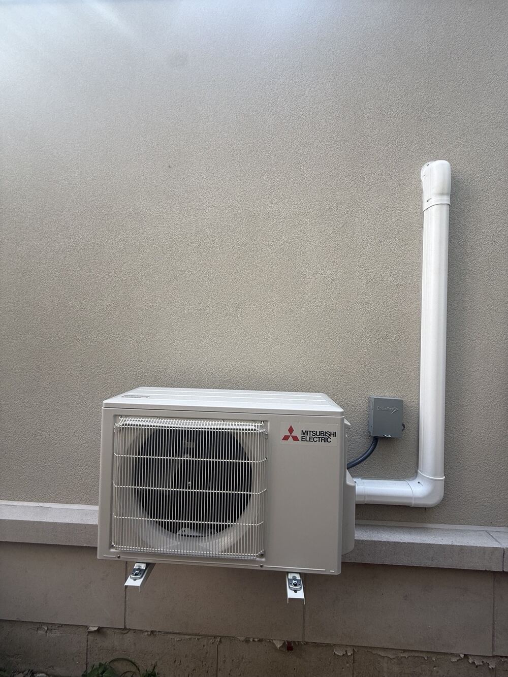 Mitsubishi Electric ductless heat-pump outdoor unit mounted on wall brackets